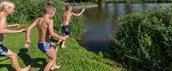 3 jongens staan op het punt om het meer in de springen
