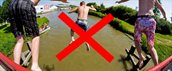 Mannen springen in het water terwijl dat verboden is