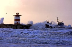 kust met pier en hoge golven