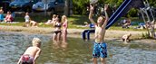 Kinderen spelen vrolijk in een meer in de zomer