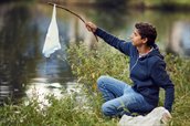 jongen vist plastic afval uit het water