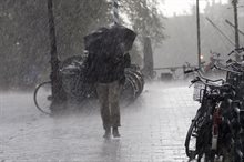 Persoon met paraplu in regenbui